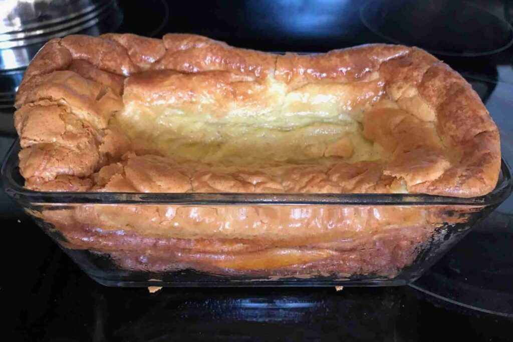 Golden brown Dutch baby pancake in a rectangular glass baking dish, slightly puffed with a crispy surface.
