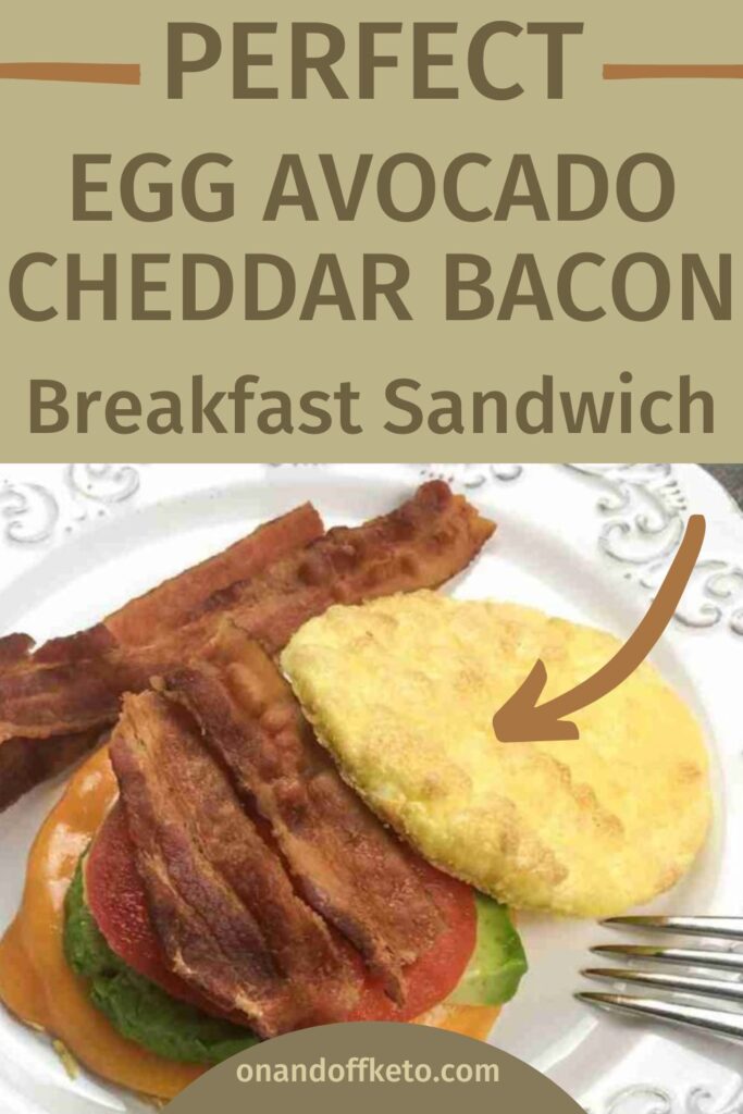 Savor a delicious breakfast sandwich featuring egg, creamy avocado, sharp cheddar, and crispy bacon elegantly presented on a white plate.