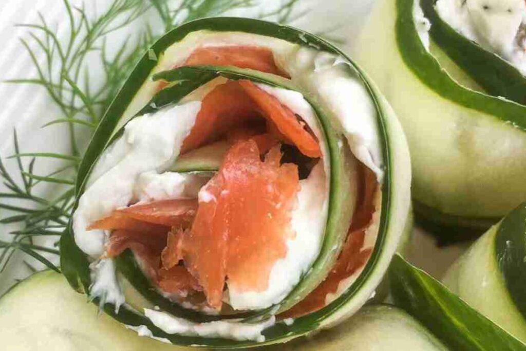Cucumber roll with smoked salmon and cream cheese, garnished with dill.