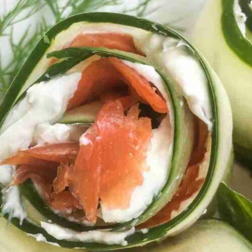 Cucumber roll with smoked salmon and cream cheese, garnished with dill.