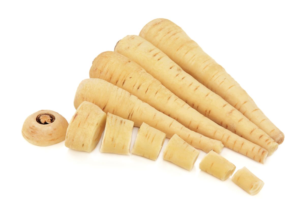Sliced and whole parsnips arranged against a white background.